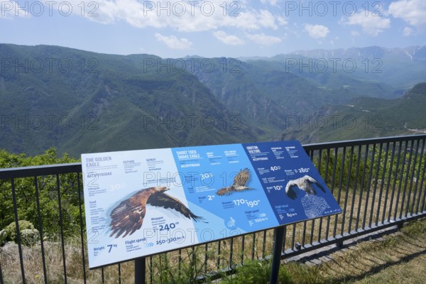 An observation deck with information boards about eagles shows a view of a mountainous landscape with blue sky, Halidzor, terrace at Wings of Tatev, Syunik province, Caucasus, Armenia