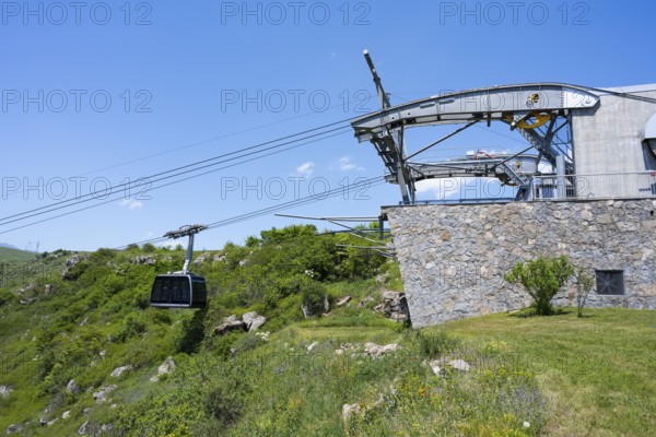 Cable car station with gondola in a green landscape, stone wall and bright blue sky, Tatev cable car, Wings of Tatev, Tatev wing, cable car station, Halidzor, Syunik province, Caucasus, Armenia