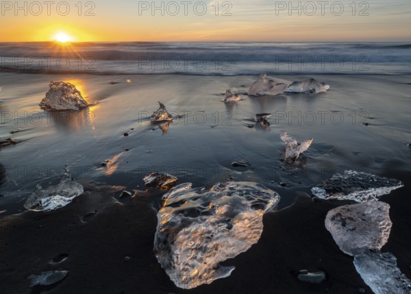 Beach with waves, ice formations, rising sun, Diamont Beach, Jökulsarlon, Iceland