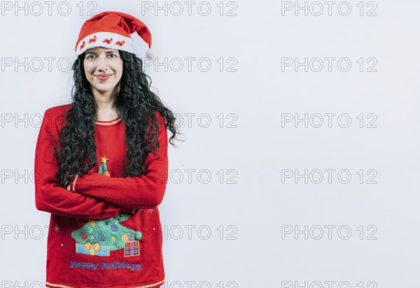 Portrait of smiling Latin girl in Christmas sweater with crossed arms, isolated. Smiling girl in Christmas hat with crossed arms