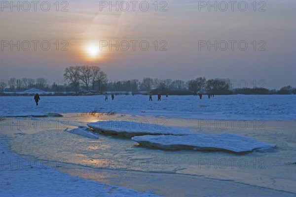 People walk across ice rink, sunset, frozen Elbe, ice floes, Bleckede, Lower Saxony, Germany, February 9, 1996, vintage, retro, old, historic