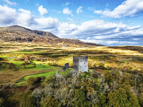 Autumn colours over Castell Dolwyddelan and Eryri Mountains from a drone, Snowdonia, Conwy County Borough, Wales, England, United Kingdom