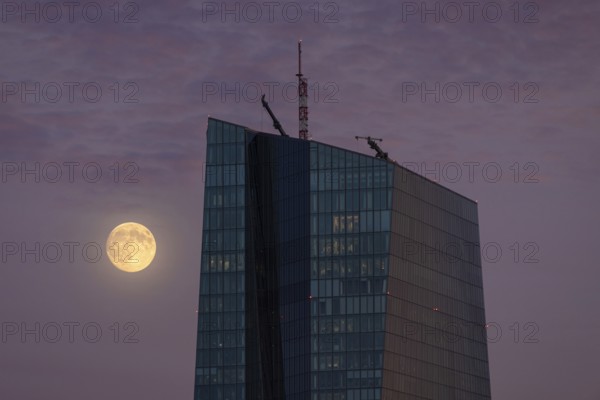The full moon passes by the European Central Bank (ECB) in Frankfurt am Main in the evening, Frankfurt, Hesse, Germany