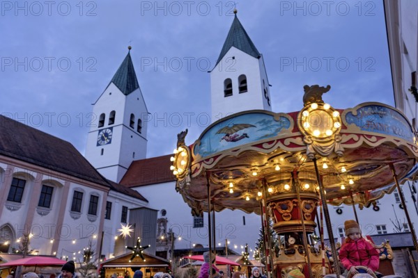 Illuminated old children's carousel, historic nostalgia carousel year 1888, Christmas market, courtyard on Domberg, Freising Cathedral St. Maria and St. Korbinian, bell towers, blue hour, Freising, Upper Bavaria, Bavaria, Germany
