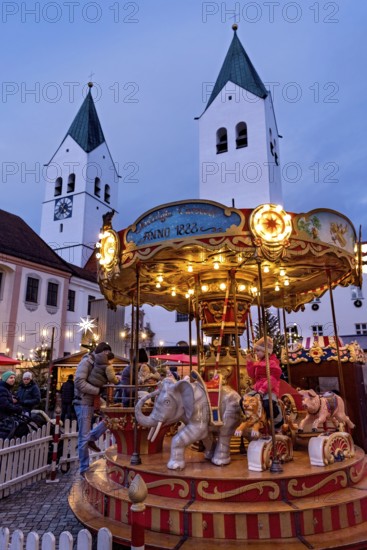 Illuminated old children's carousel, historic nostalgia carousel year 1888, Christmas market, courtyard on Domberg, Freising Cathedral St. Maria and St. Korbinian, bell towers, blue hour, Freising, Upper Bavaria, Bavaria, Germany