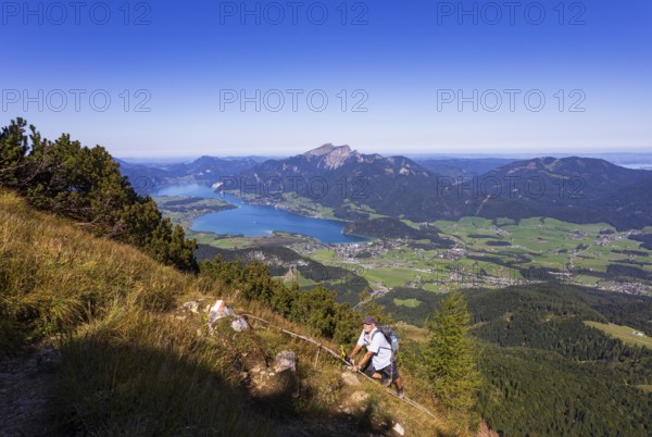Hikers at the Iron Ladder on the way to Rettenkogel with Wolfgangsee, Postalm, Osterhorn Group, Salzkammergut, Province of Salzburg, Austria