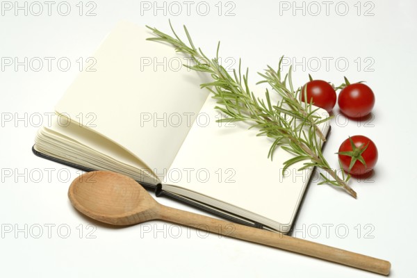 Blank notebook for cooking recipes, cooking spoon with rosemary sprig, tomato