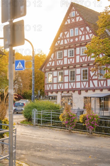 Half-timbered house in autumn surroundings with street lighting and flowers, Aidlingen, Böblingen district, Germany