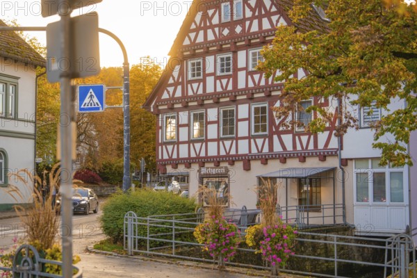 Cosy half-timbered house in autumn light with street sign and flowers, Aidlingen, Böblingen district, Germany