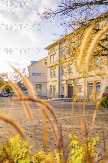 Sunny village square with historic building and autumn plants, Aidlingen, Böblingen district, Germany