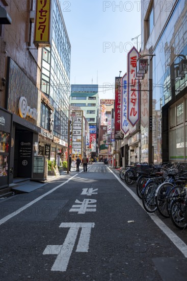 Street scene, lots of colorful signs of shops, restaurants and bars in a street, Shinjuku City, Tokyo, Japan
