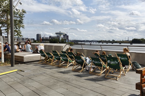 Sun loungers on the Elbe promenade with views of the Elbe and the harbor, tourist group, Westfield Überseequartier, modern shopping center, HafenCity, Hamburg, Germany