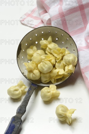 Saccottini, type of Italian pasta in a sieve ladle, pasta from Italy