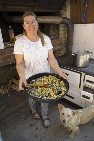 Serbian woman showing przeno or traditional Serbian dish in her kitchen, Vrmdza, Sokobanja, Serbia