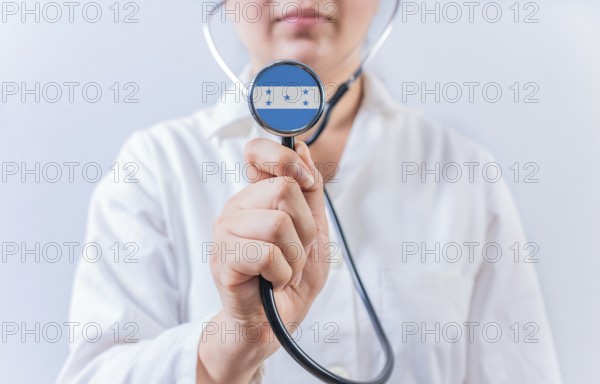 Female doctor holding stethoscope with Honduras flag. National health system of Honduras