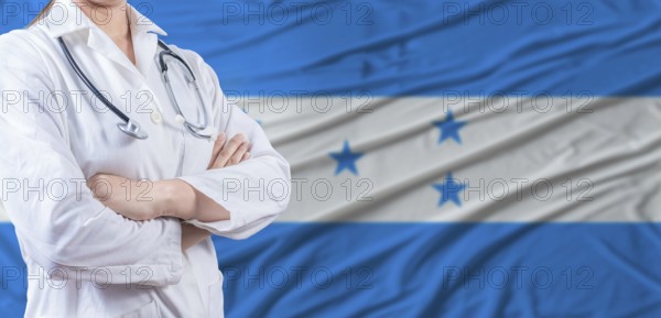 Doctor with crossed arms on Honduras flag. Honduras health and care concept. Female doctor on Honduras flag