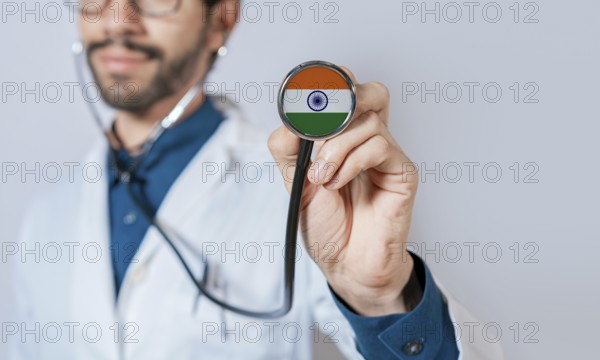 Doctor holding stethoscope with India flag. India health and care concept. India flag on stethoscope