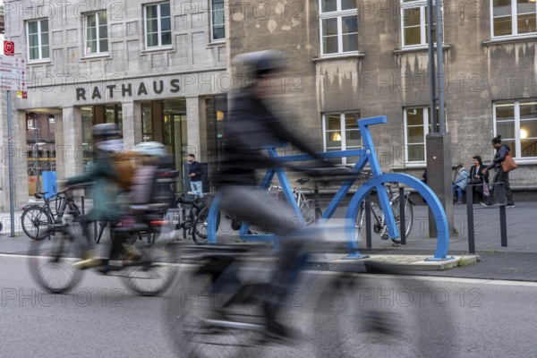 Bicycle parking spaces, with so-called leaning bars and a large blue bicycle silhouette, to make parking spaces visible at Bochum City Hall, North Rhine-Westphalia, Germany