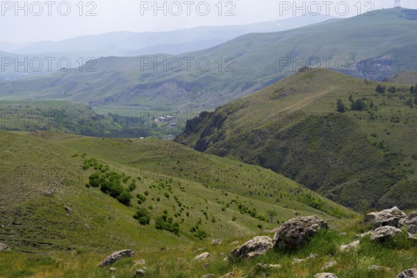 Extensive green hilly landscape with rocky sections under cloudy sky, landscape near Zorats Karer, Zorakarer, Karahundsch, Sisian, Sissian, Sjunik province, historic Sangesur, Armenia