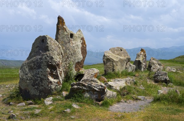 Protruding stones in a meadow under a cloudy sky, stone circle, megaliths, Zorats Karer, Karahundsch, Bronze Age burial ground, Sisian, Sissian, Syunik province, historic Sangesur, Armenia