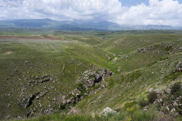 Green hills with a gorge under a cloudy sky, landscape near Zorats Karer, Zorakarer, Karahundsch, Sisian, Sissian, Syunik province, historic Sangesur, Armenia