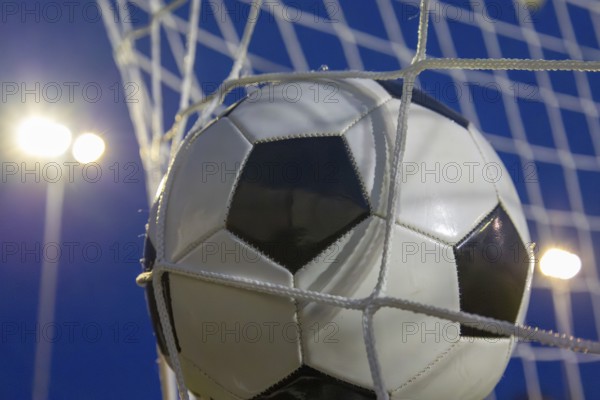 Soccer symbol: close-up of a soccer ball under floodlights