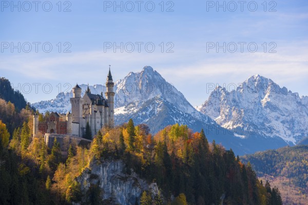Neuschwanstein towers over an autumnal valley and magnificent snow-covered mountain formations, Schwangau near Füssen, Ostallgäu, Allgäu, Bavaria, Germany