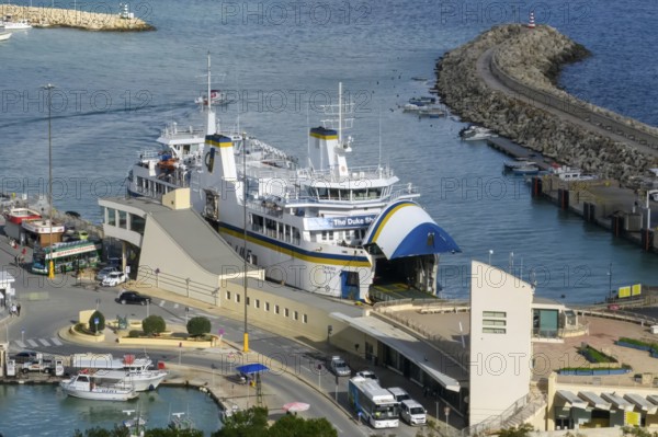 Car ferry with roll-on roll-off RoRo method for ship with two flaps for entry exit for ferry traffic between the island of Malta and the island of Gozo is located with the flap open in Mgarr Port, Gozo Malta
