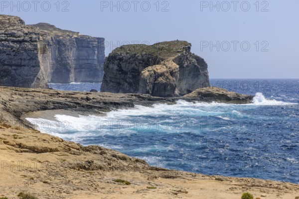 Rough rough sea surf during autumn storm high rugged cliffs burn on beach coast on the Mediterranean Sea of Gozo Island, Gozo, Malta