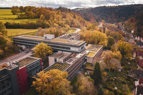 Autumn drone view of a building complex surrounded by forest and nature, Calw District Office, Calw, Germany
