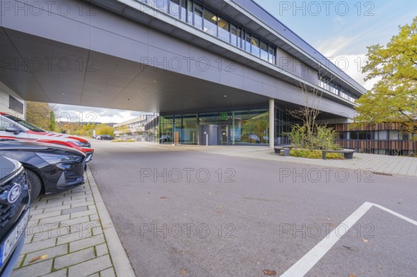 Parking lot in front of a modern, grey office building under clear skies, Calw District Office, Calw, Germany