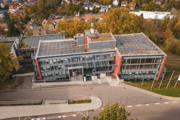 Modern office building with solar panel on the roof and surrounding autumn trees, Calw District Office, Calw, Germany