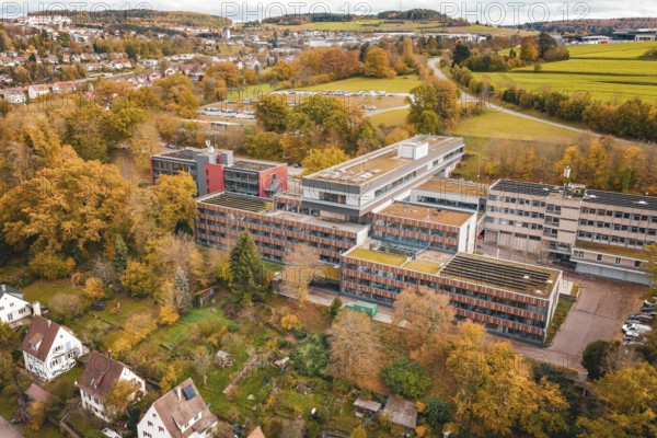 Multi-storey building complex with colorful autumn trees in rural surroundings, Calw District Office, Calw, Germany