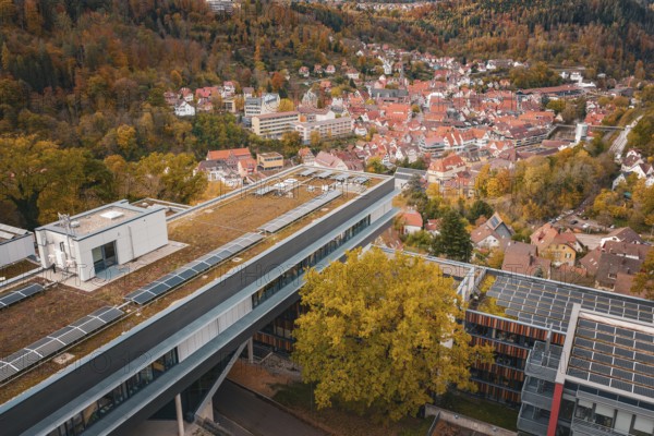 View of a modern building with tiled roofs and surrounding autumn landscape, Calw District Office, Calw, Germany
