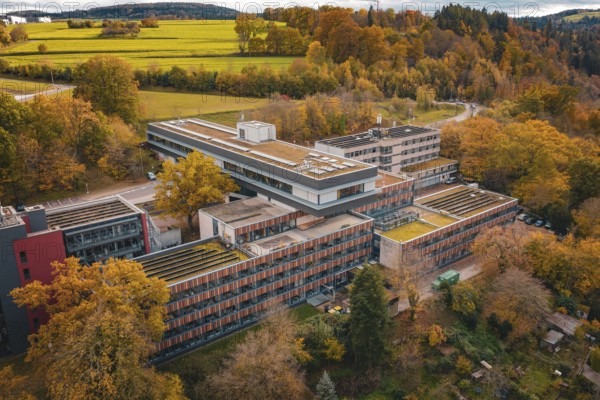 Building complex surrounded by autumnal nature with advanced roof design, Calw District Office, Calw, Germany