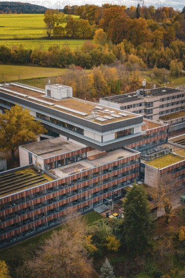Modern architecture with surrounding forests and meadows in autumn colors, solar cells visible, Calw District Office, Calw, Germany