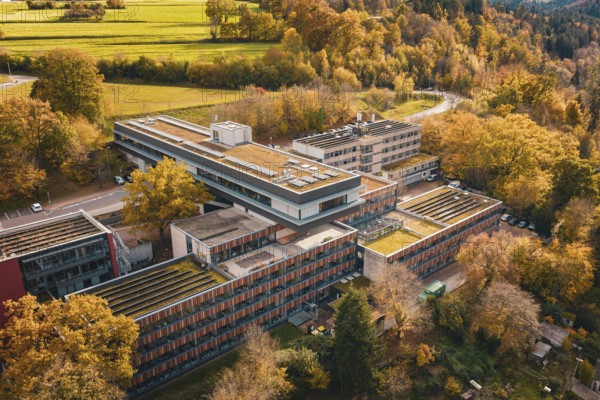 Building complex in a hilly, autumnal area with flat roof and solar cells, Calw District Office, Calw, Germany