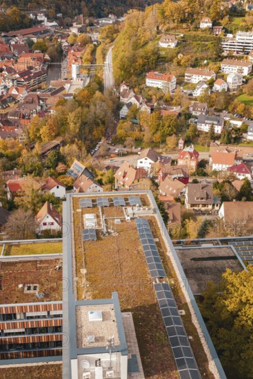 Building with a flat roof and solar cells next to an idyllic, autumnal urban landscape, Calw District Office, Calw, Germany