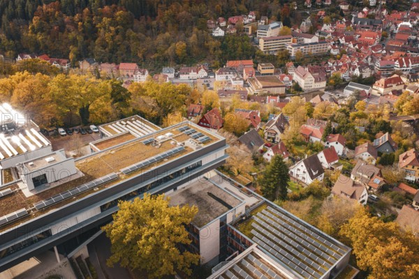 View of a town with residential buildings and surrounding autumn landscape, including a modern building, Calw District Office, Calw, Germany