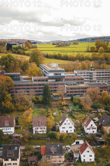 View of village with autumn trees and fields, dominating clouds in the sky, Calw District Office, Calw, Germany