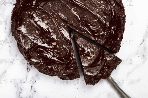 Chocolate cake, round cake, on a marble light table, top view, homemade cakes, no people