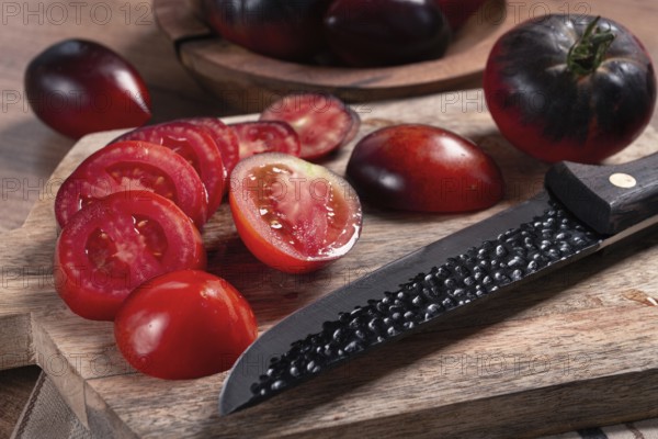 Sliced tomatoes, Black Beauty variety, on a cutting board, top view, on the kitchen table