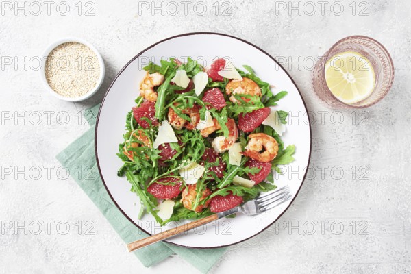 Fresh shrimp salad with arugula, grapefruit, and parmesan served in a bowl