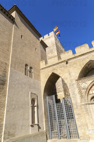 Looking up at historic tower and ramparts in courtyard of historic castle, Aljafería Palace, Zaragoza, Aragon, Spain