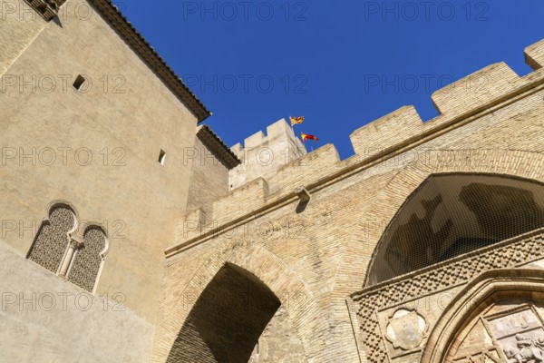 Looking up at historic tower and ramparts in courtyard of historic castle, Aljafería Palace, Zaragoza, Aragon, Spain