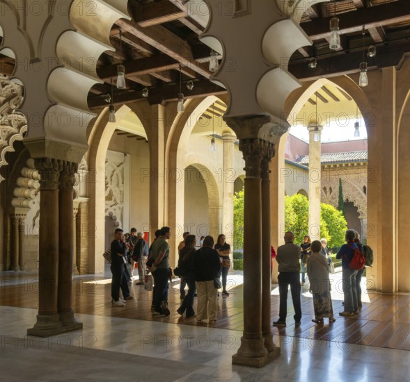 Tour group tourists viewing Moorish arches, Aljafería Palace, Zaragoza, Aragon, Spain