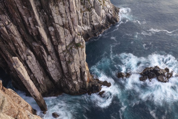 Totem Pole Long exposure at sunrise shows glowing dawn over the dramatic cliffs of Cape Hauy. Waves hit the steep cliffs. Cape Hauy, Tasman Peninsula, Tasmania, Australia