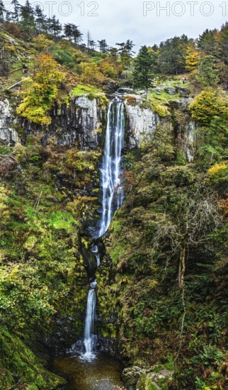 Autumn colours over Pistyll Rhaeadr Waterfall and Berwyn Mountains from a drone, Oswestry, Shrewsbury, Wales, England, United Kingdom