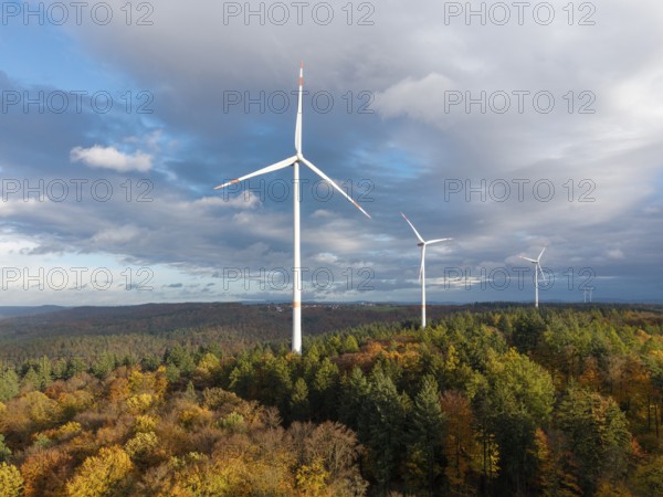 Three wind turbines above an autumnal forest against a cloudy sky, near Schorndorf, Remstal, Rems-Murr-Kreis, Baden-Württemberg, Germany