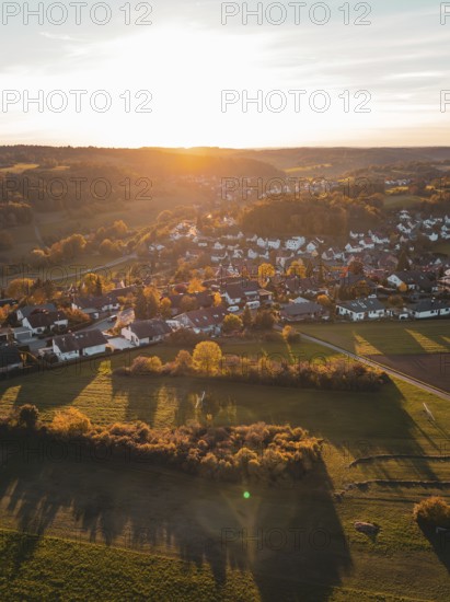 View of a village at dusk surrounded by autumnal fields, Deufringen, Aidlingen, Böblingen district, Germany